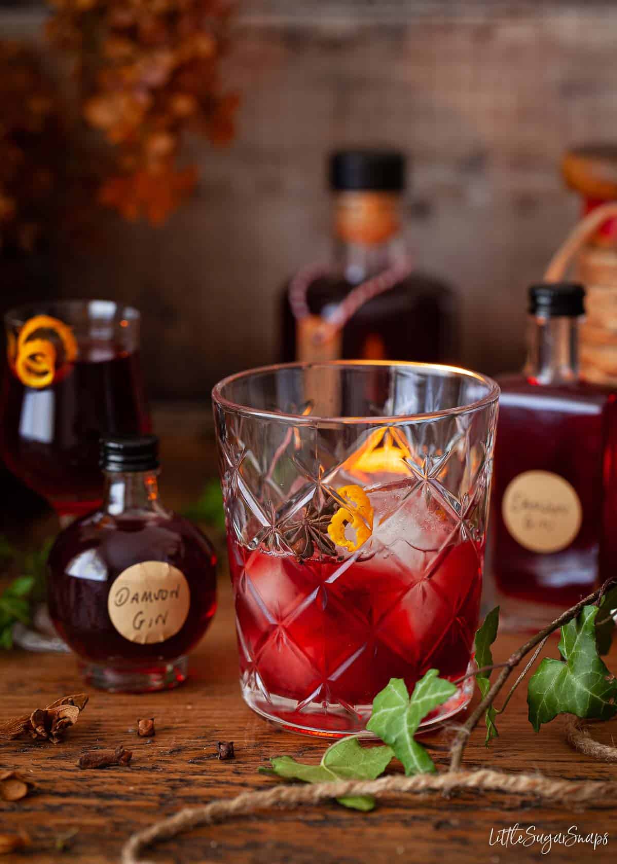 A serving of damson gin liqueur served over ice with an orange zest garnish