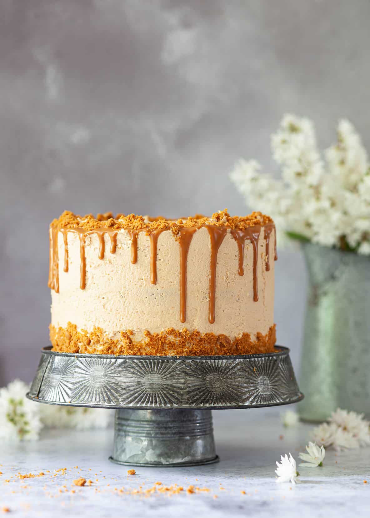 Vegan Biscoff drip cake decorated with buttercream, crushed cookies and Biscoff drip