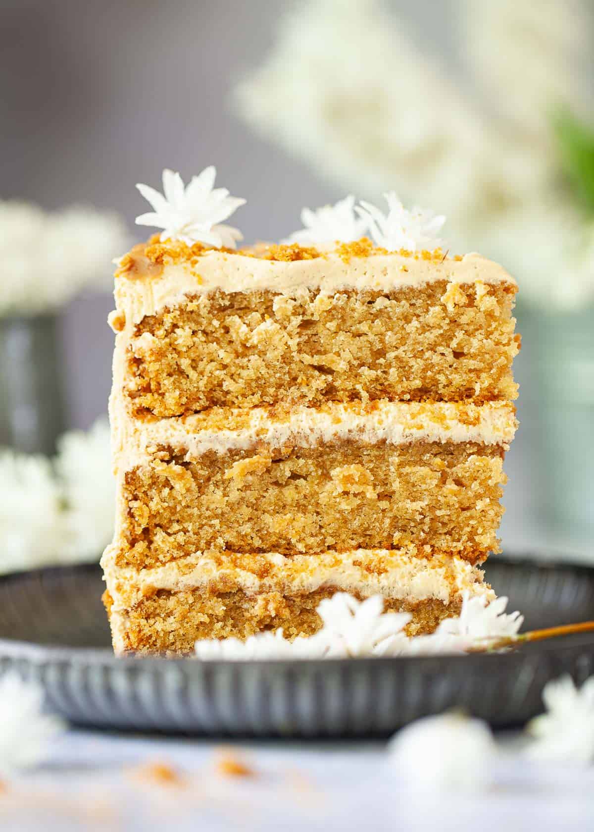 A slice of vegan Lotus Biscoff layer cake with cookie butter frosting