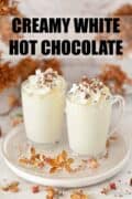 two glass mugs of white hot chocolate with cream plus text overlay