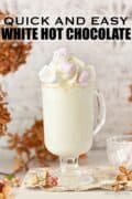 Glass mug of white hot chocolate with cream & mini marshmallows plus text overlay
