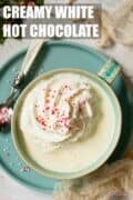 Mug of white hot chocolate with cream and sprinkles plus text overlay