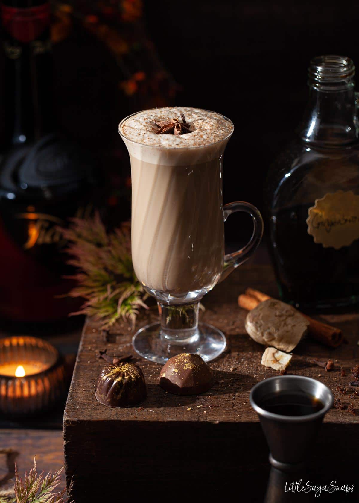 A glass of Christmas gingerbread spiced latte with frothy milk on top.