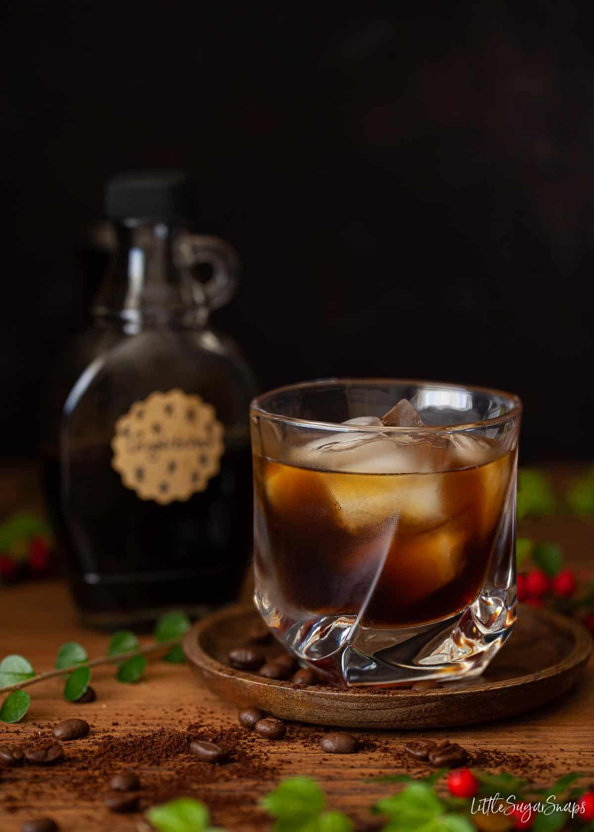 A bottle of gingerbread syrup and a kahlua cocktail served over ice.