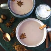 Mugs of hot cocoa with cinnamon sticks and star anise garnishes.