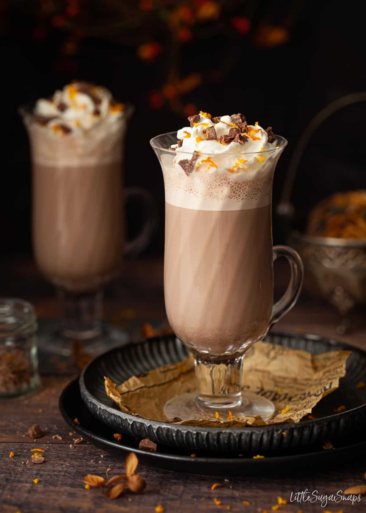 Hot chocolate orange drink with whipped cream, orange zest and grated chocolate.