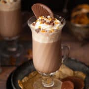 A hot chocolate topped with cream and a Terry's Chocolate Orange Segment.