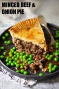 A slice of minced beef pie with peas and gravy. Image has text overlay.