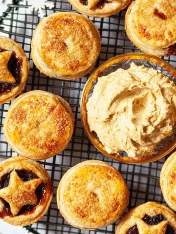 Close up image of puff pastry mince pies with advocaat butter on a cooling rack.