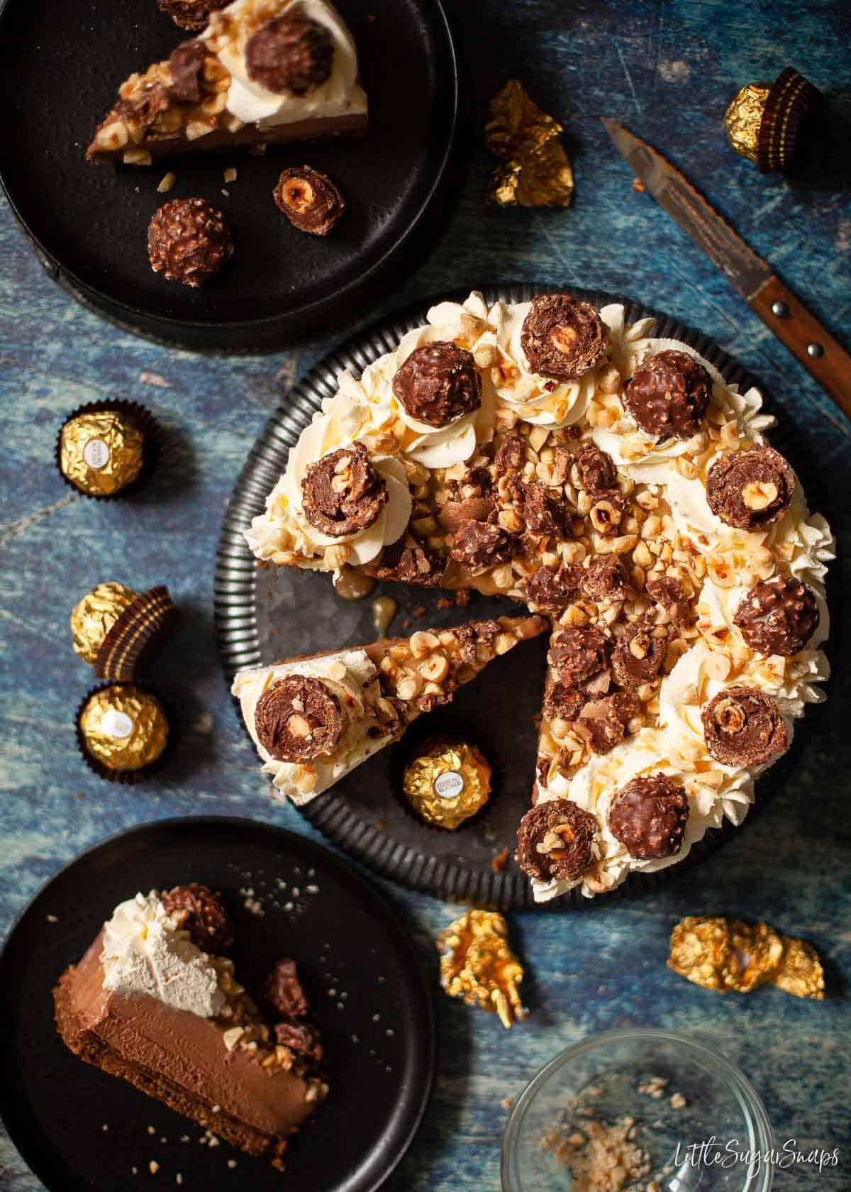 Overhead view of Ferrero Rocher Cheesecake partially cut into slices.