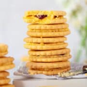 A stack of custard creams biscuits with one bitten into.