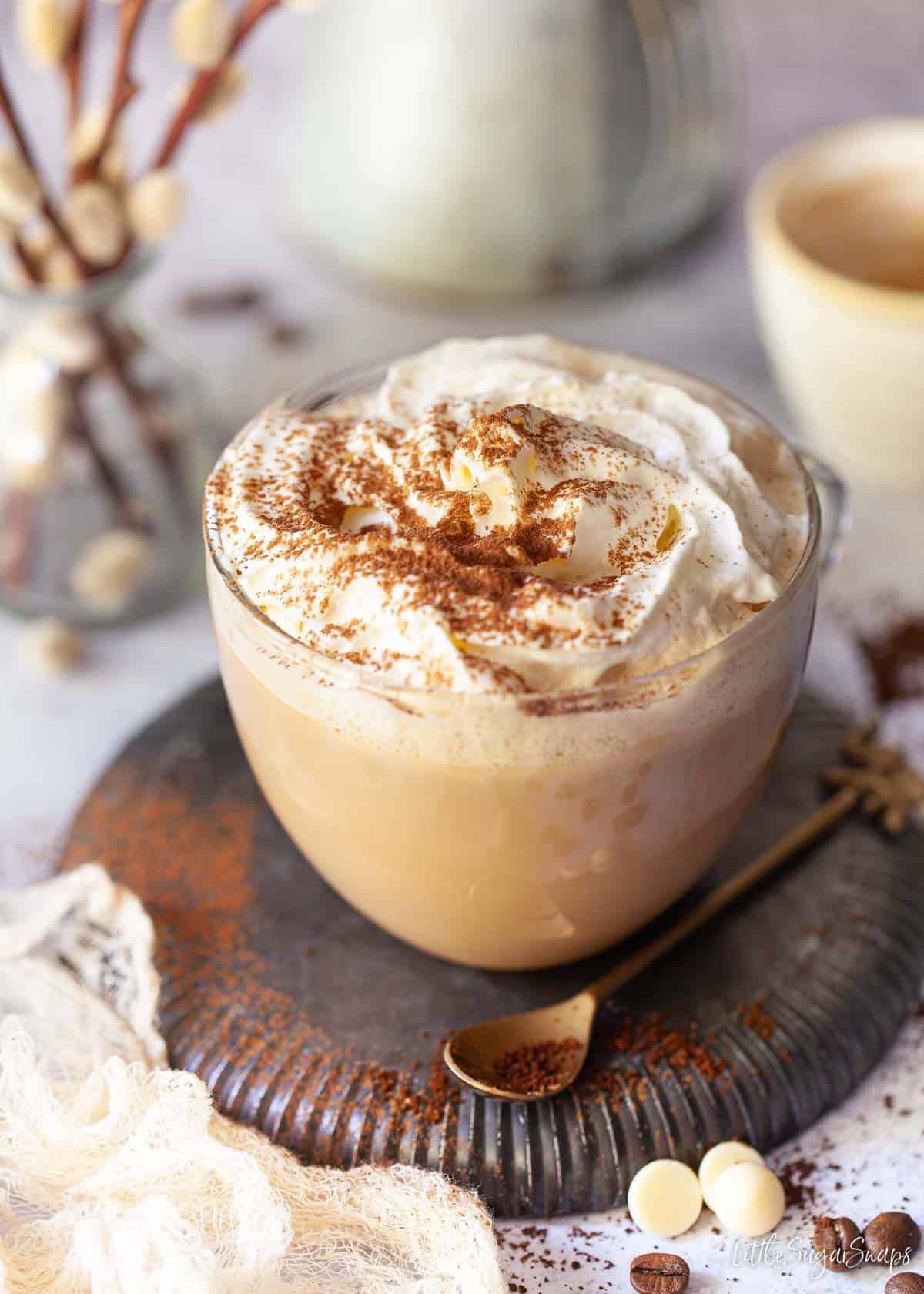 A white chocolate mocha coffee drink topped with cream and cocoa powder.