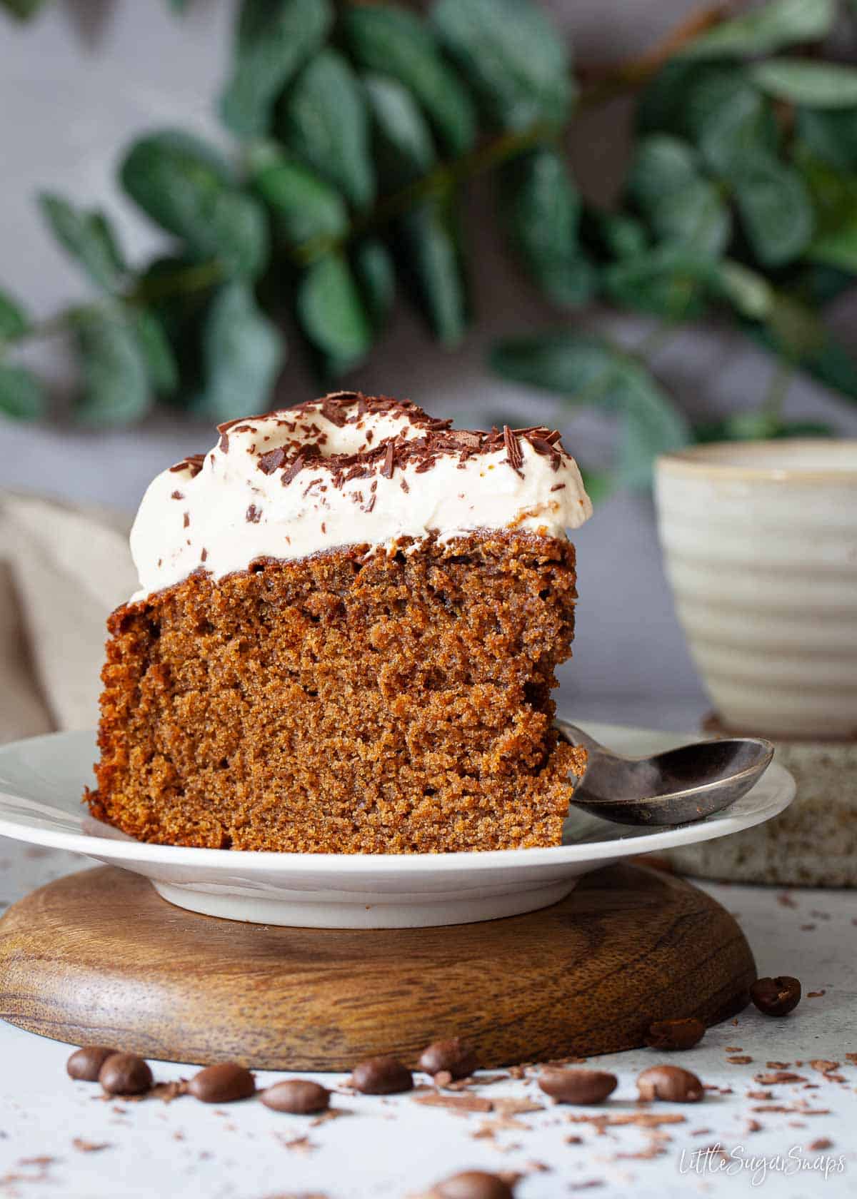 A slice of irish coffee cake on a plate. It's topped with Baileys whipped cream.
