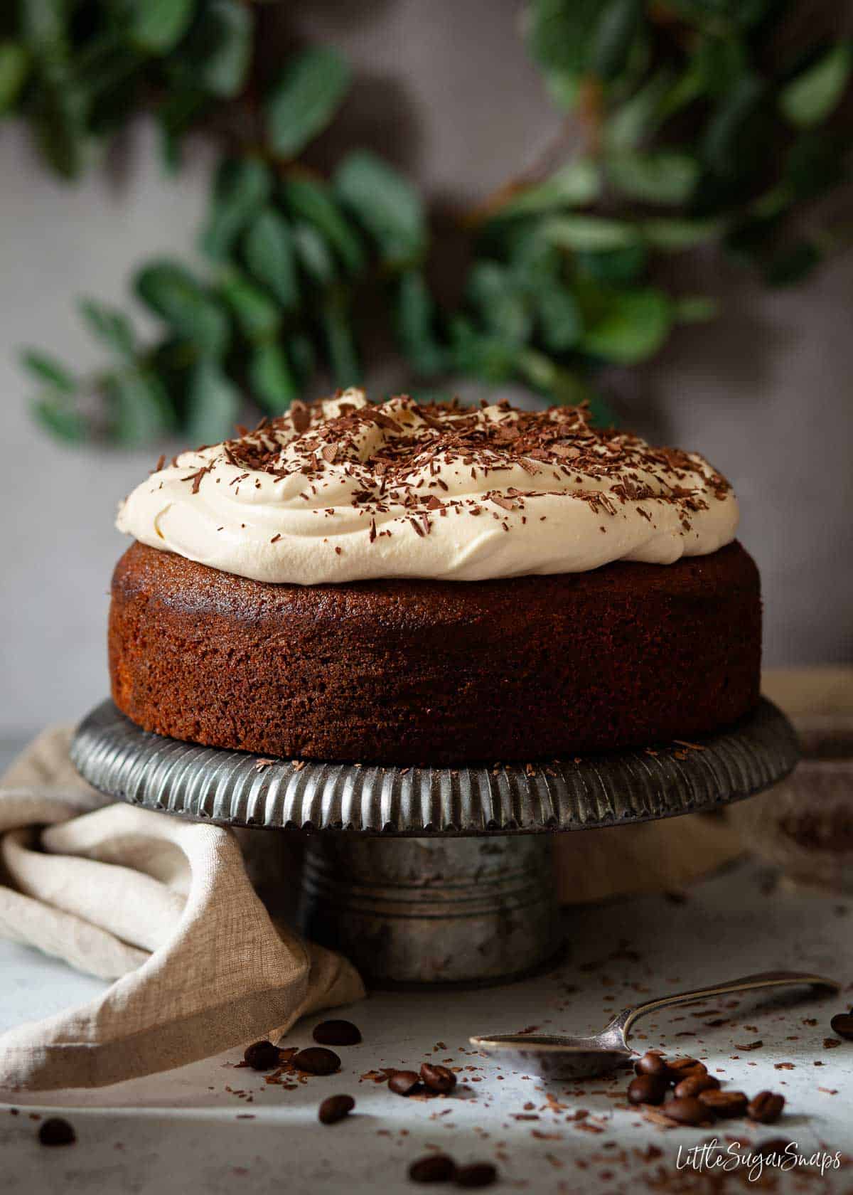 Baileys Irish coffee cake on a stand. Topped with whipped cream.