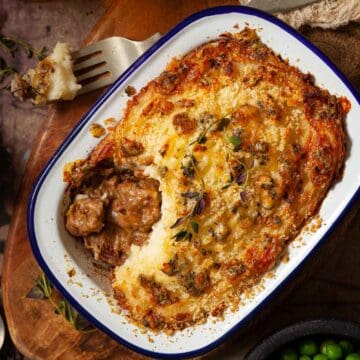 A part eaten steak and stilton pie in an enamel pot.