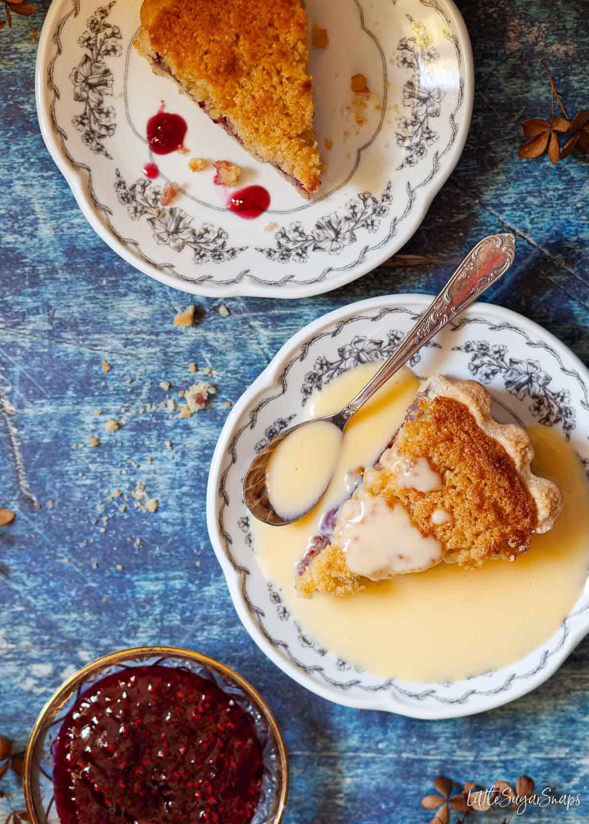 Overhead view of slices of Buxton pudding served with custard.