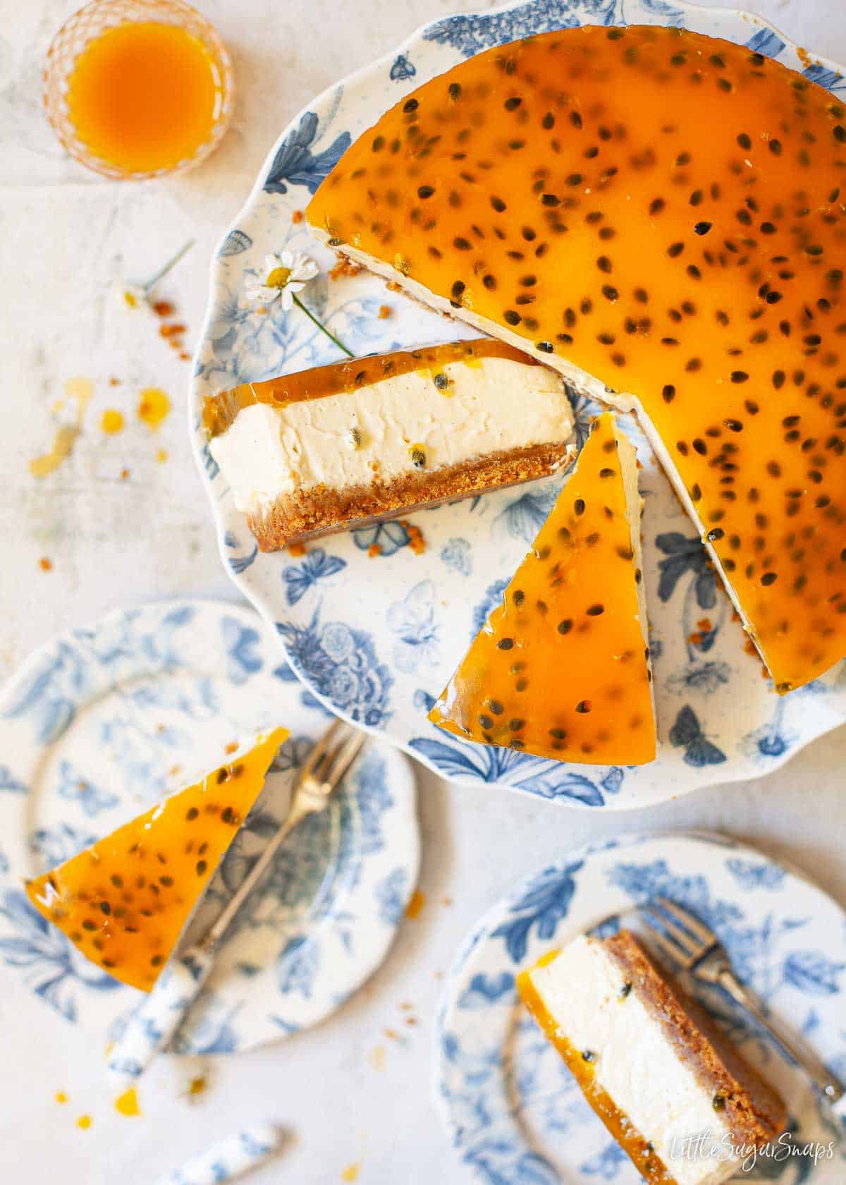 A no-bake passionfruit cheesecake being sliced and served.