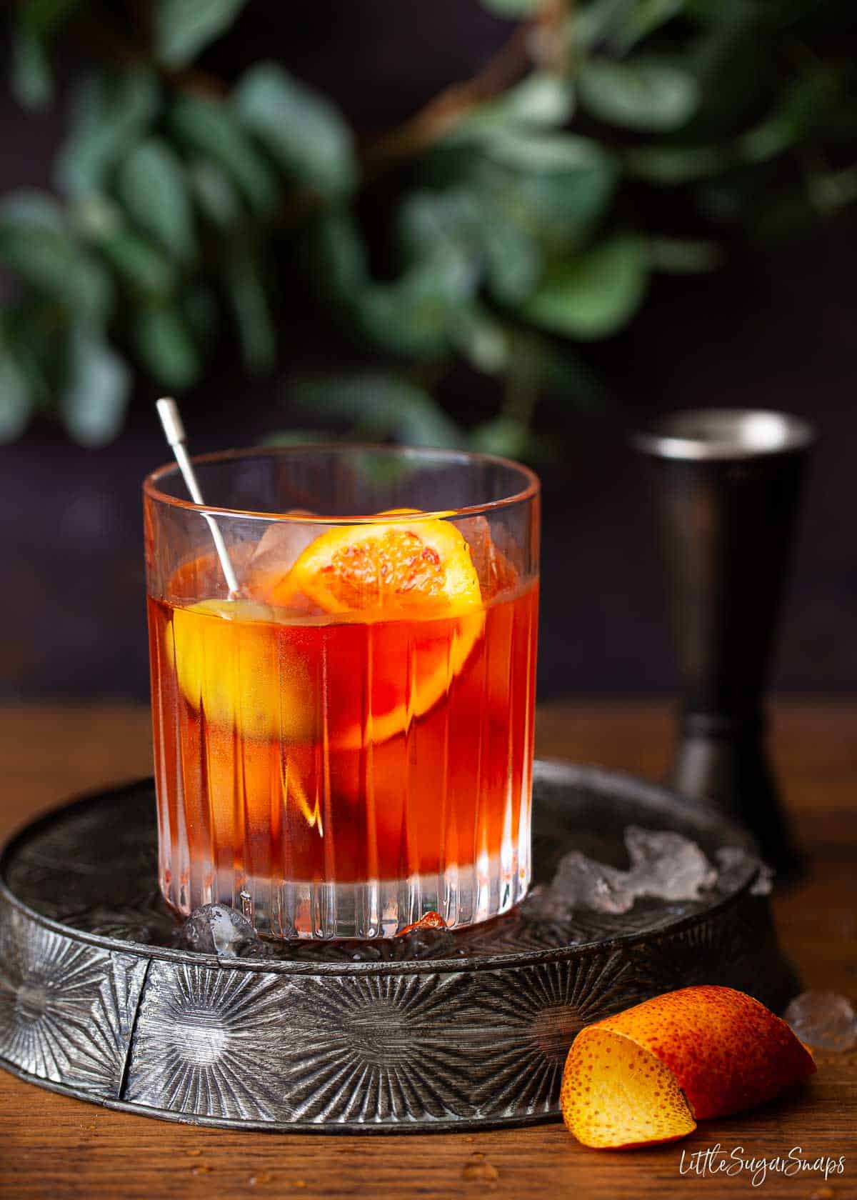 Negroni made with Italian Orange Aperol Bitters and garnished with olives and a slice of orange.