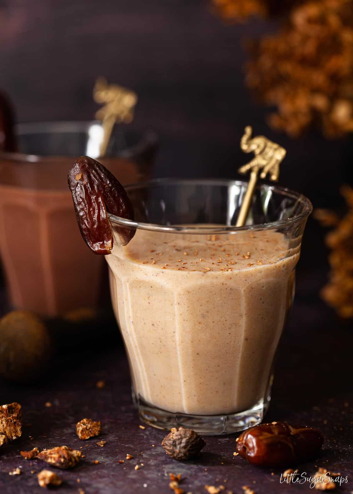 Two healthy date shake milkshakes. One is flavoured with spices and the other with chocolate.