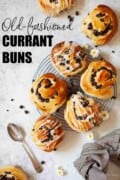 Currant buns on a wire rack with text overlay.