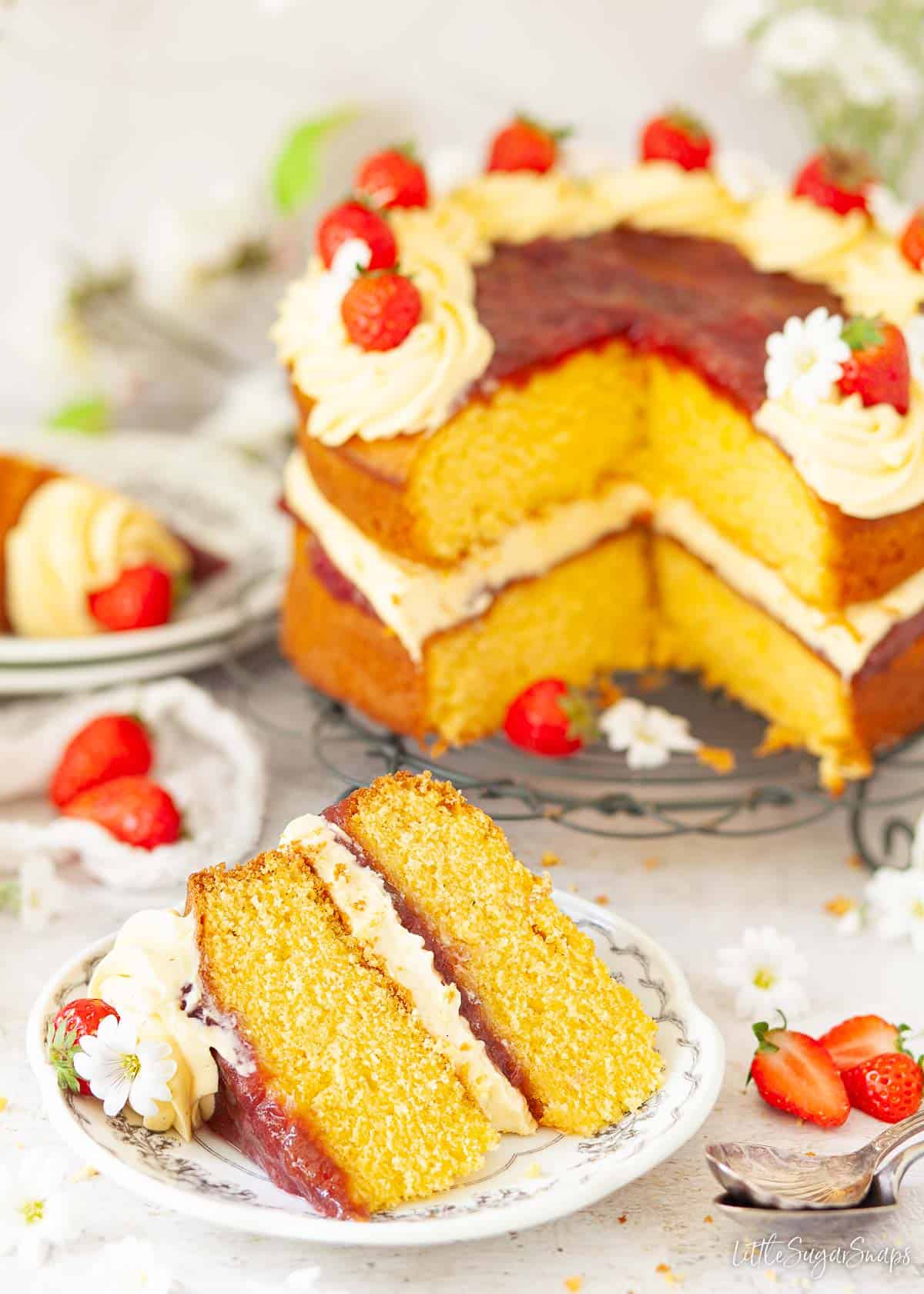 A custard powder sponge cake with a slice on a plate.