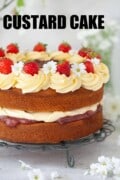 Custard sponge cake topped with custard cream, rhubarb compote and strawberries. With text overlay.