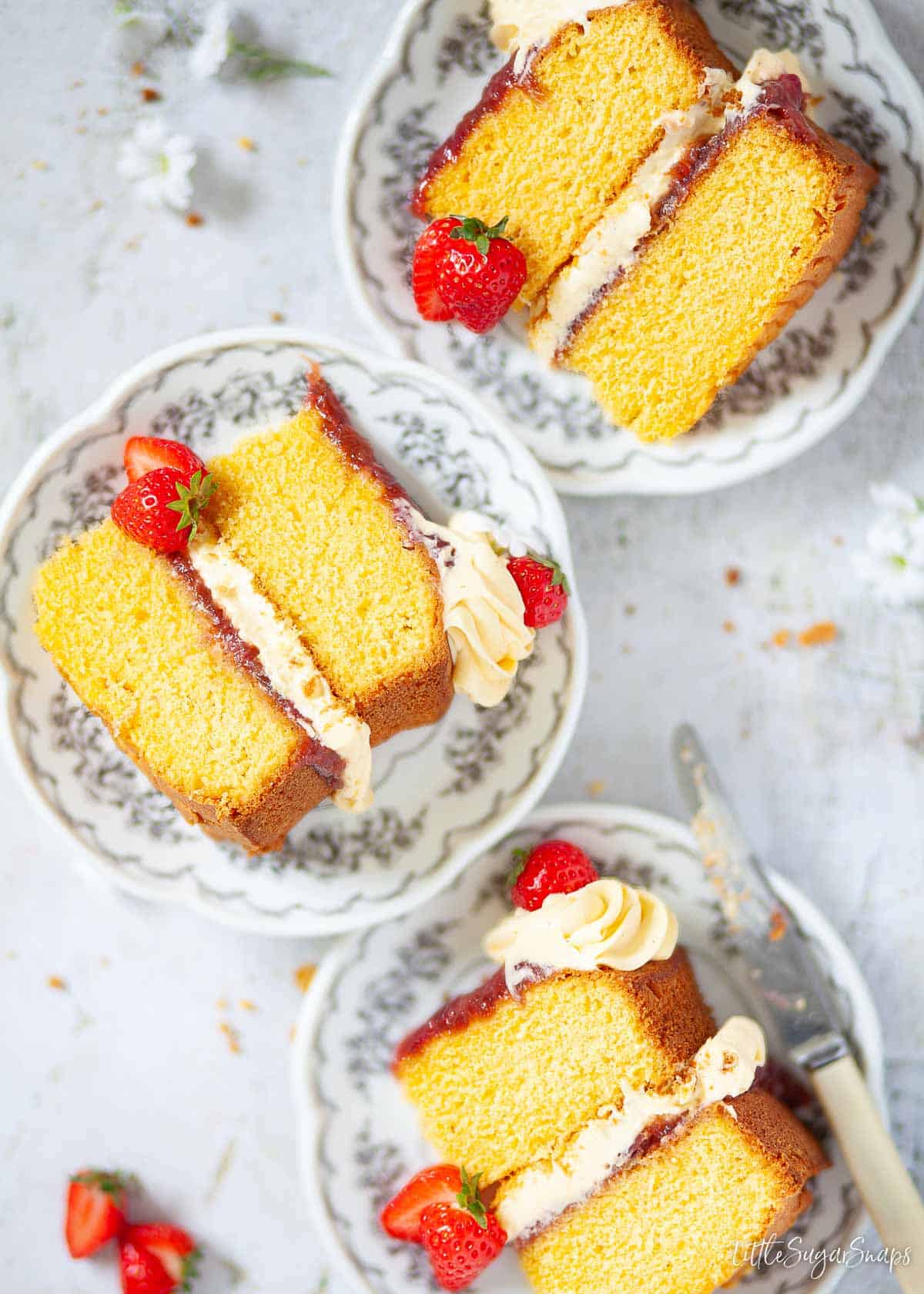 Three slices of custard cake on small plates.