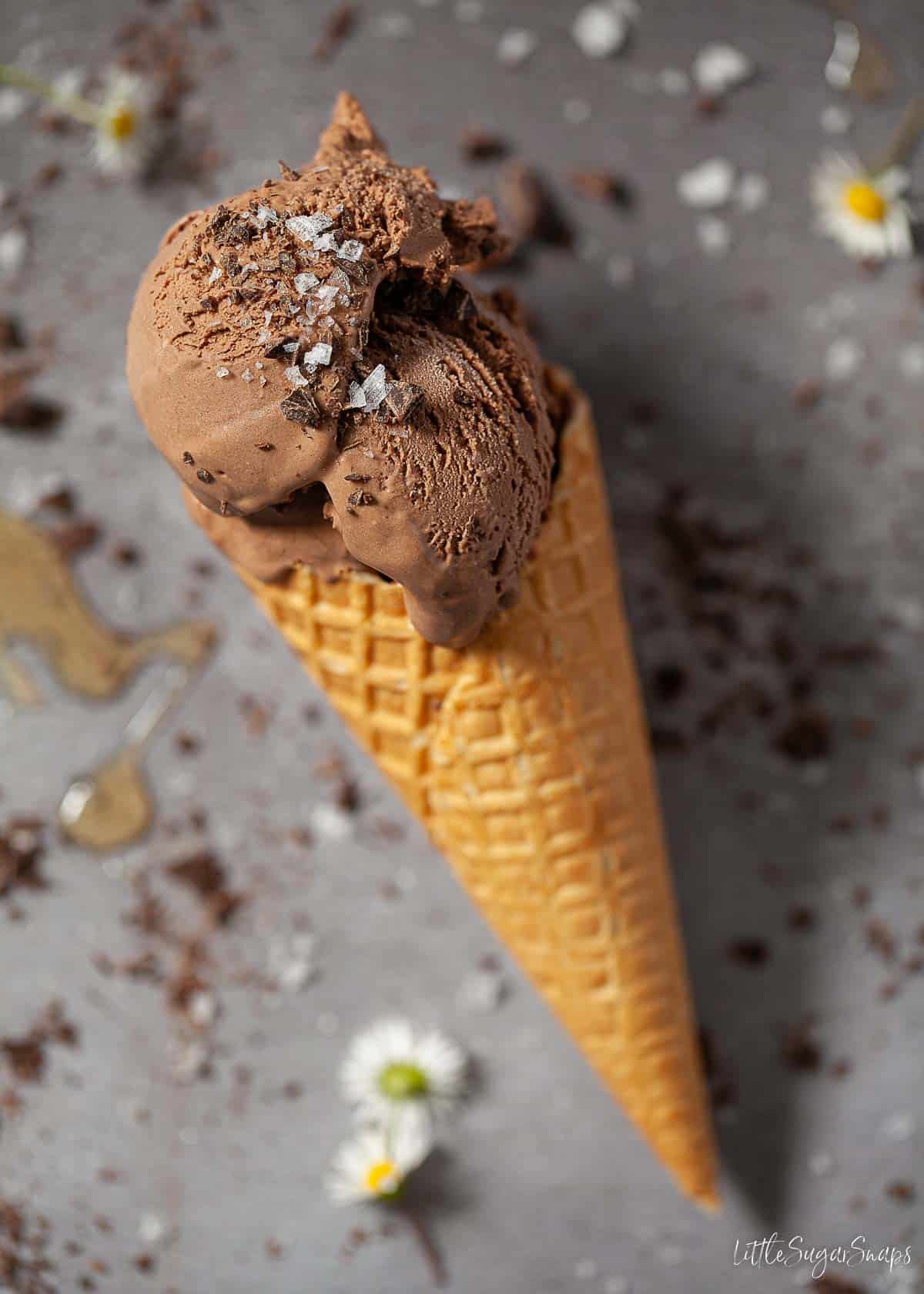 Dark chocolate ice cream in a waffle cone with sea salt and chopped chocolate.