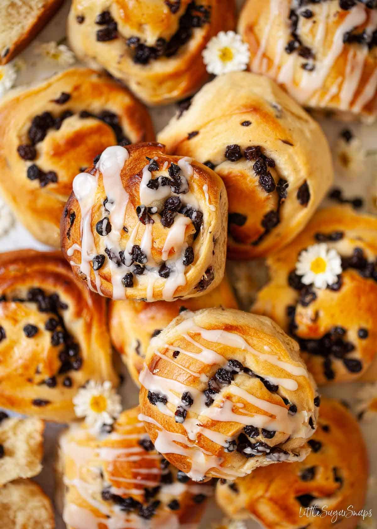 A selection of unglazed and glazed currant buns.