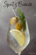 White spritz with lemon, rosemary and olive garnish with text overlay.