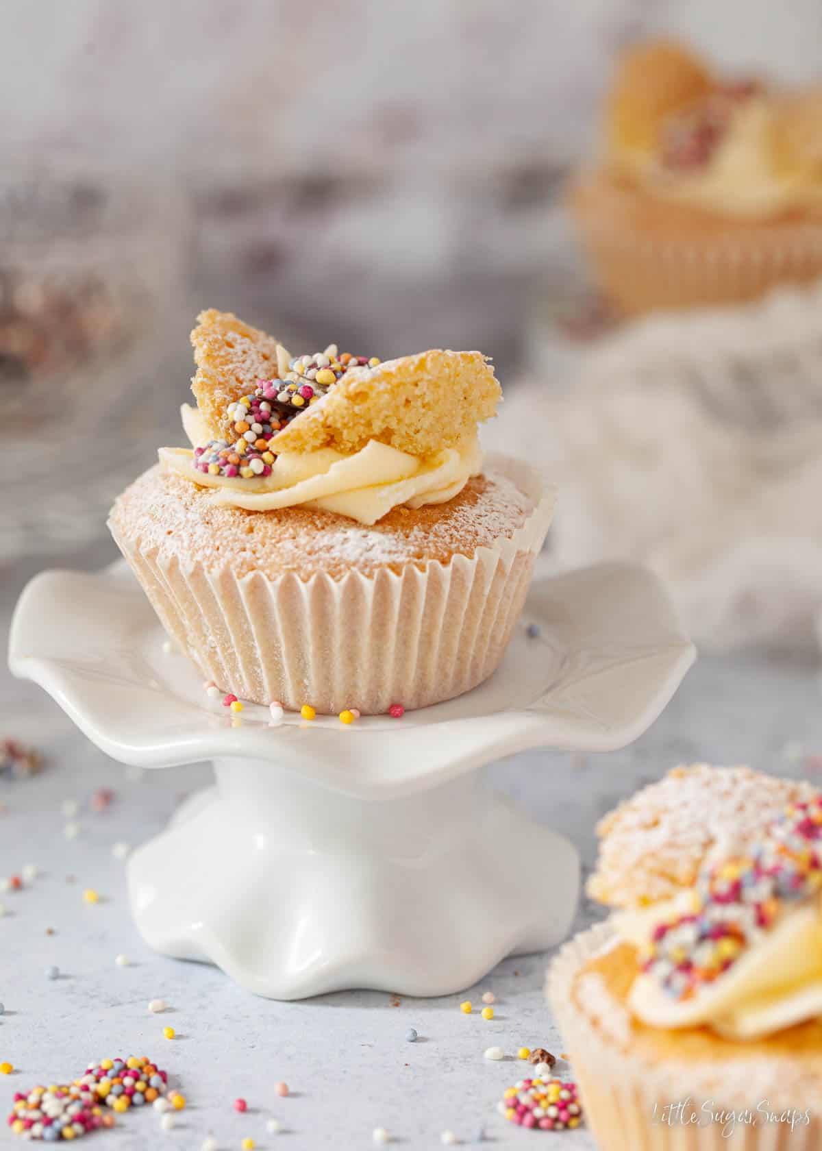 A vanilla butterfly cake filled with buttercream. It's on a cakestand.