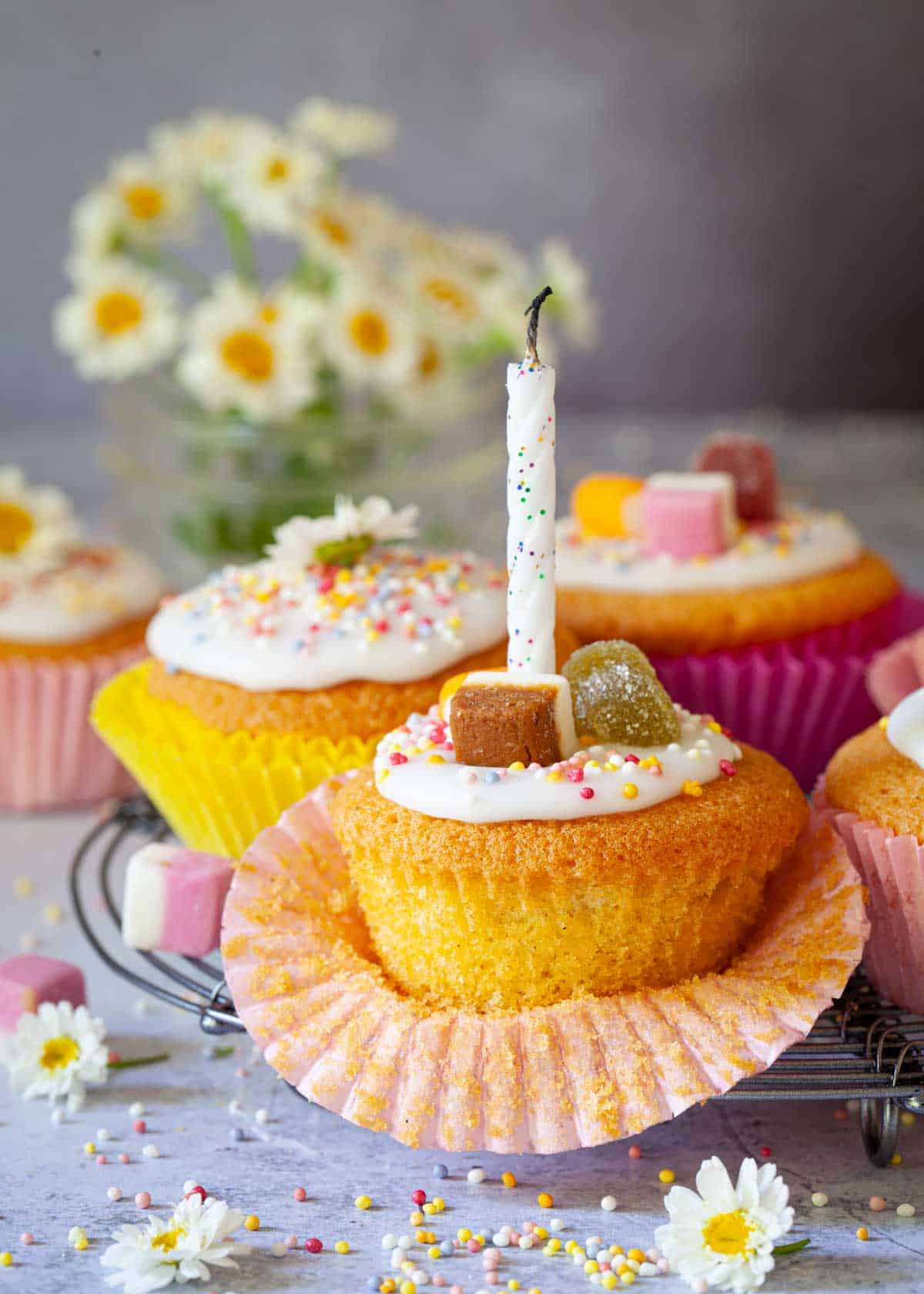 Several fairy cakes, one with a blown out candle in it.