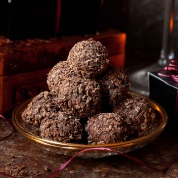 Manhattan cocktail flavoured truffles stacked on a vintage plate.