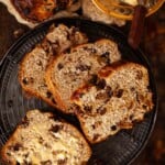 Slices of Lincolnshire plum bread on a plate. One slice has been buttered.