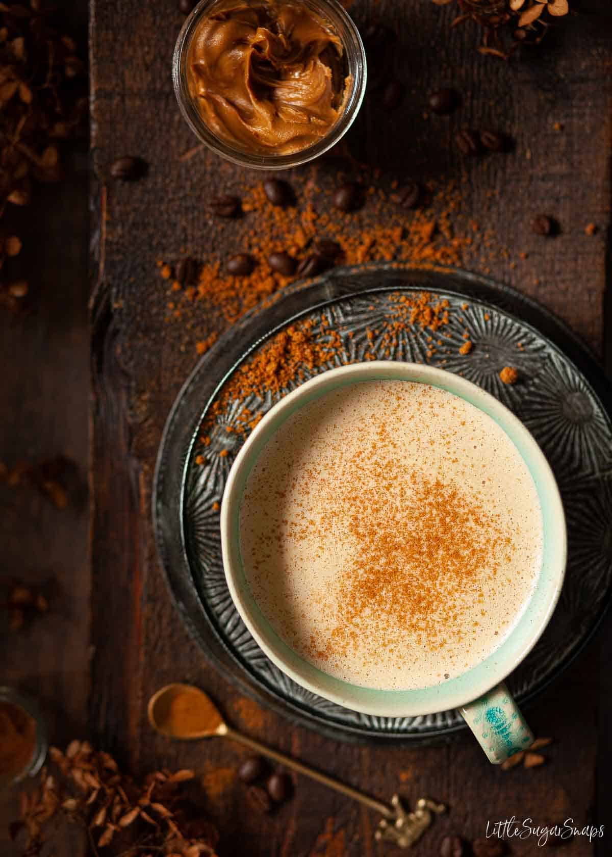 Biscoff latte in a mug and sprinkled with ground cinnamon.