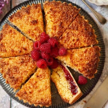 Close-up of a sliced coconut tart with jam.