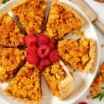 Close-up of school cornflake tart sliced and served with frsh raspberries.