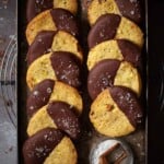 Pistachio biscuits that have been dipped in dark chocolate and sprinkled with sea salt.