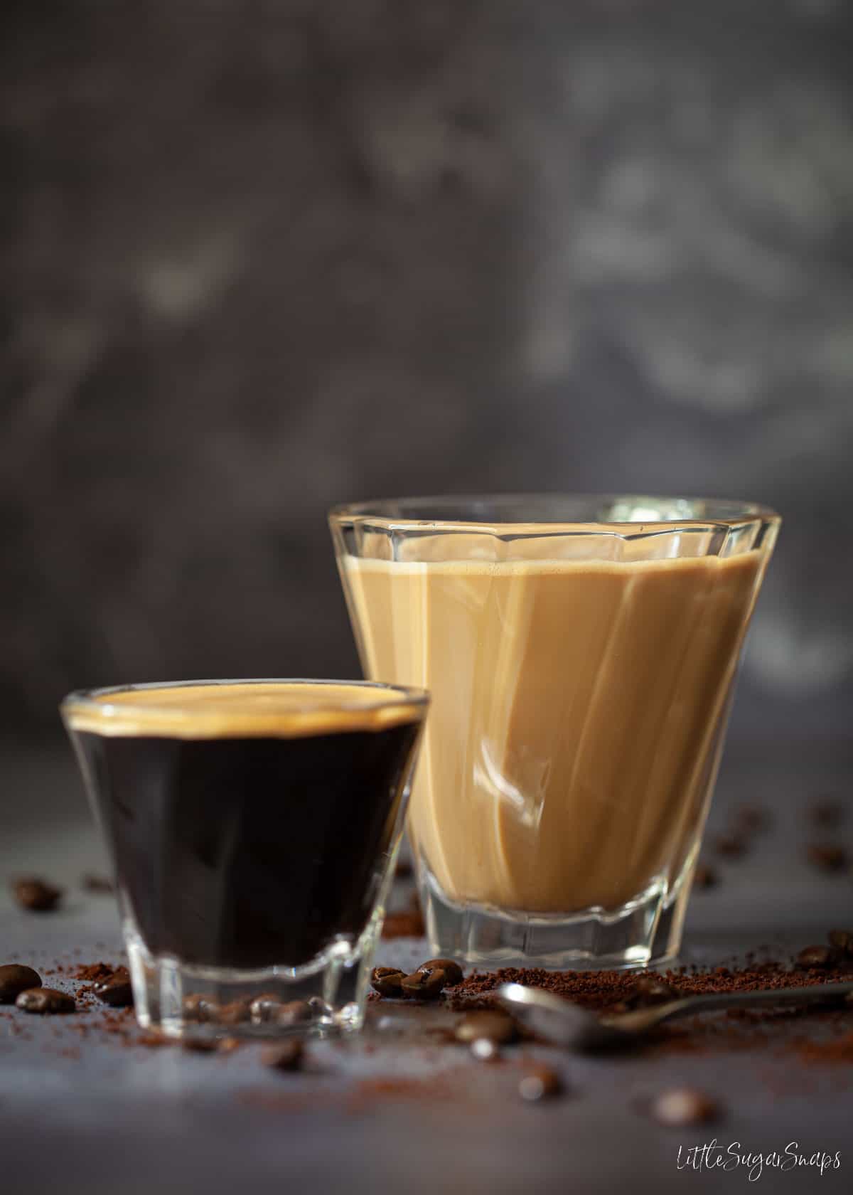 A glass of café con leche and an espresso shot alongside.