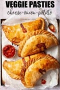 Labelled vegetarian pasties on a baking sheet.