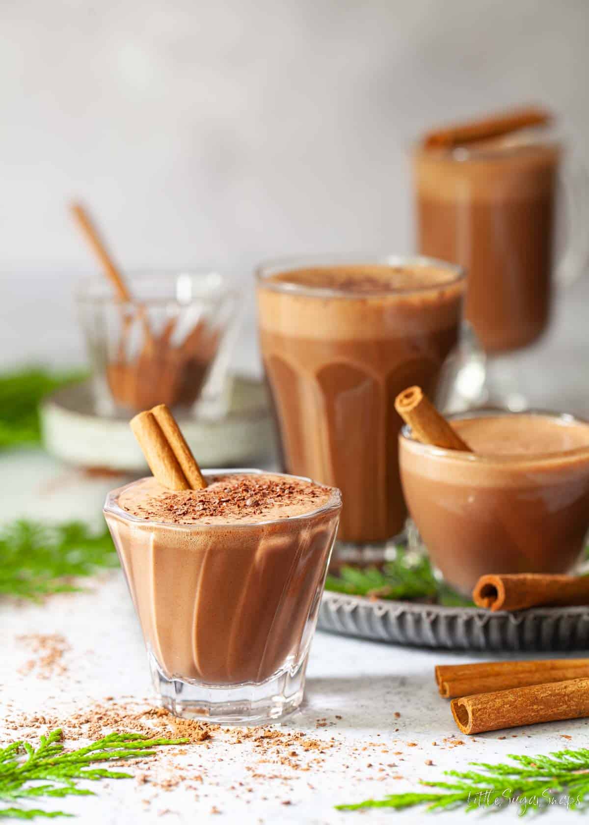 Cinnamon hot chocolate garnished with chocolate and cinnamon sticks.