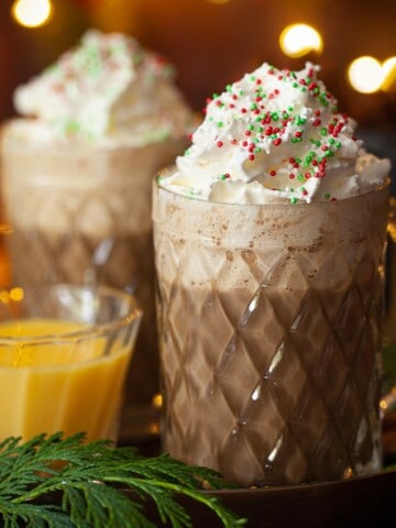 Close-up of Christmas latte with whipped cream and sprinkles.