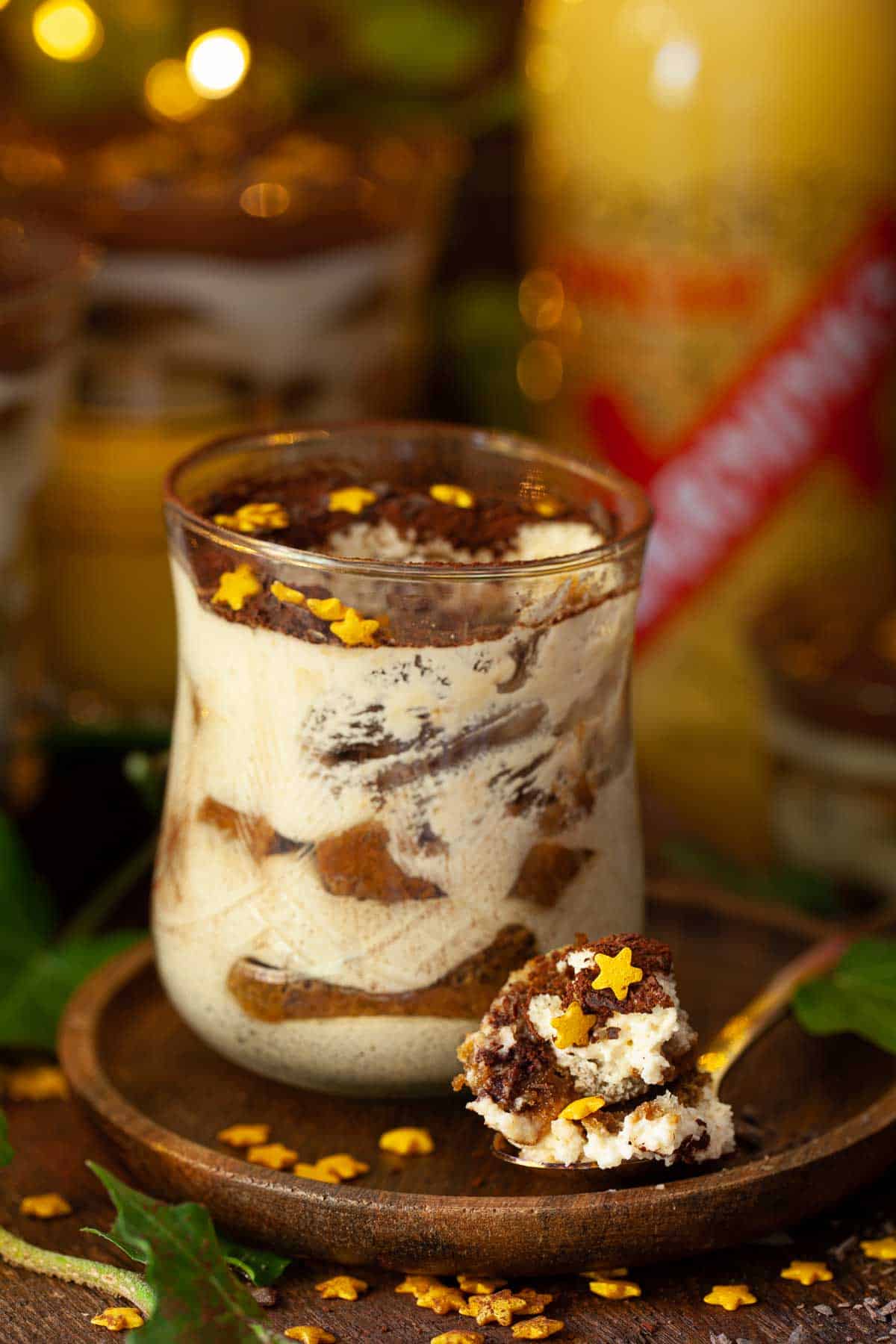 A part eaten mini tiramisu in a glass.