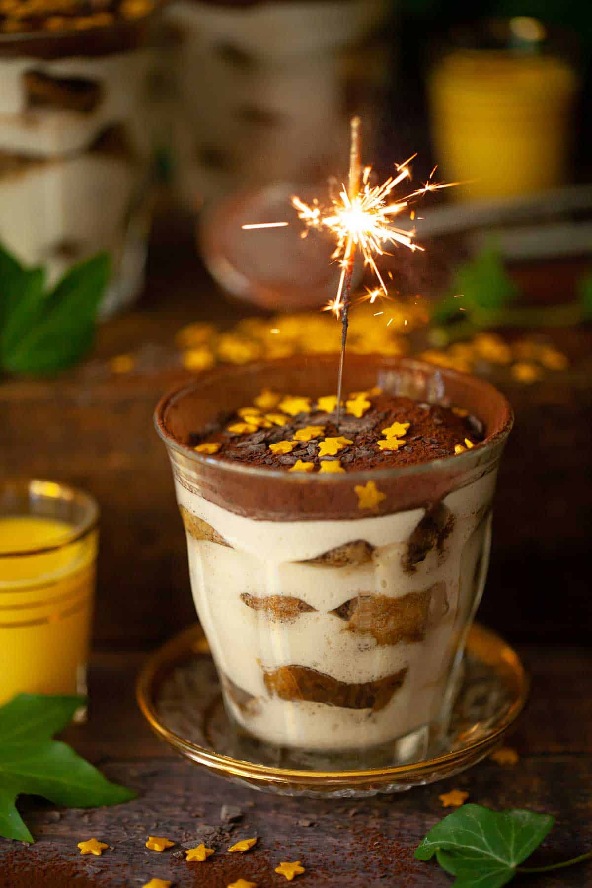 Tiramisu in a glass with a lit sparkler.