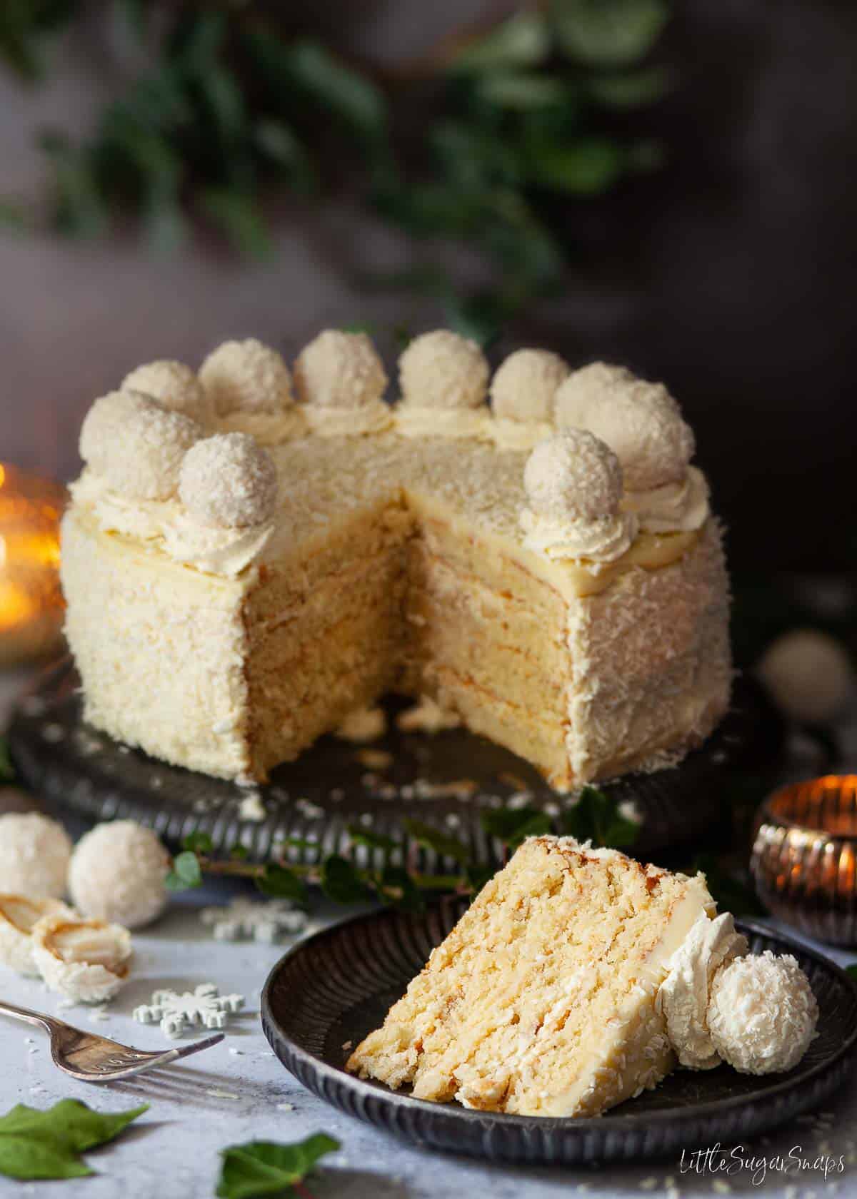 Cut into Raffaello cake with almond torte layers covered in desiccated coconut.