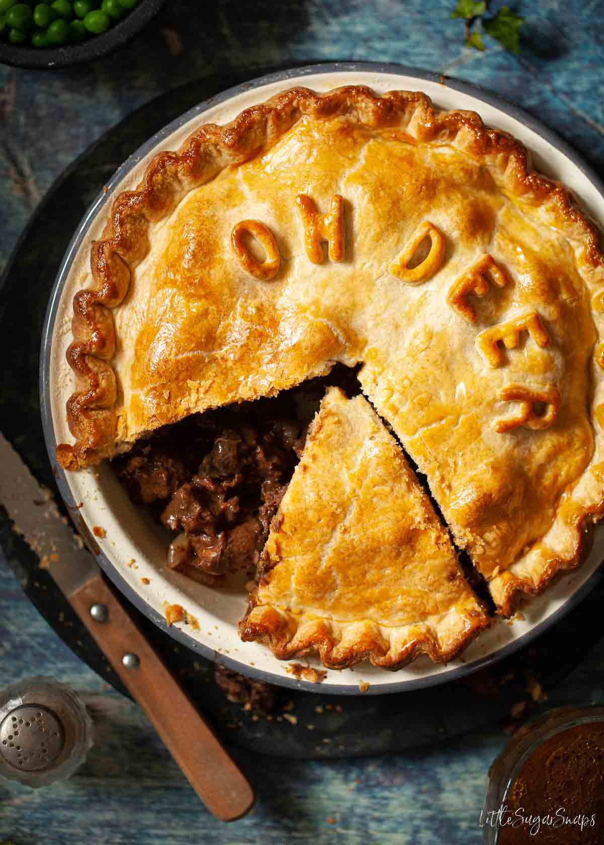 Venison pie with a slice cut and removed to reveal the filling.