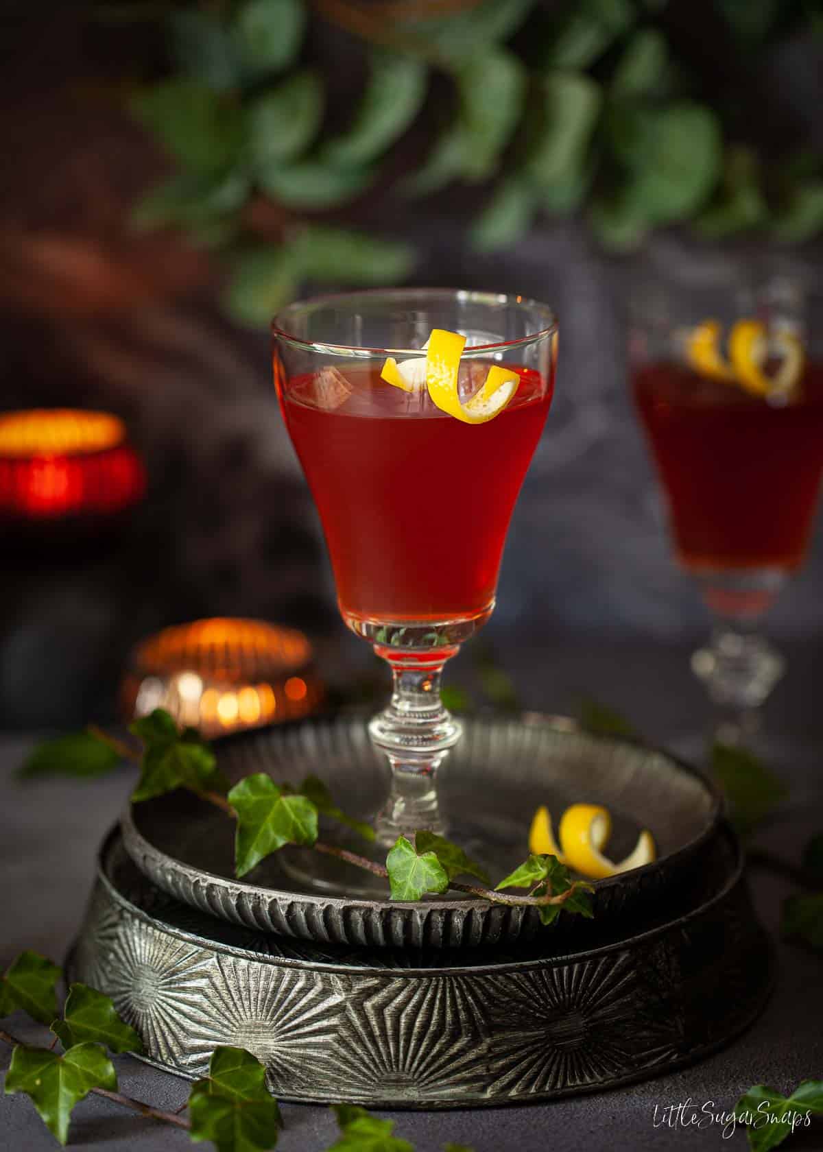 An Amaro Montenegro cocktail in a tall glass with a lemon twist for garnish.