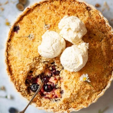 Close up of a large fruit dessert in a serving dish with a portion removed.