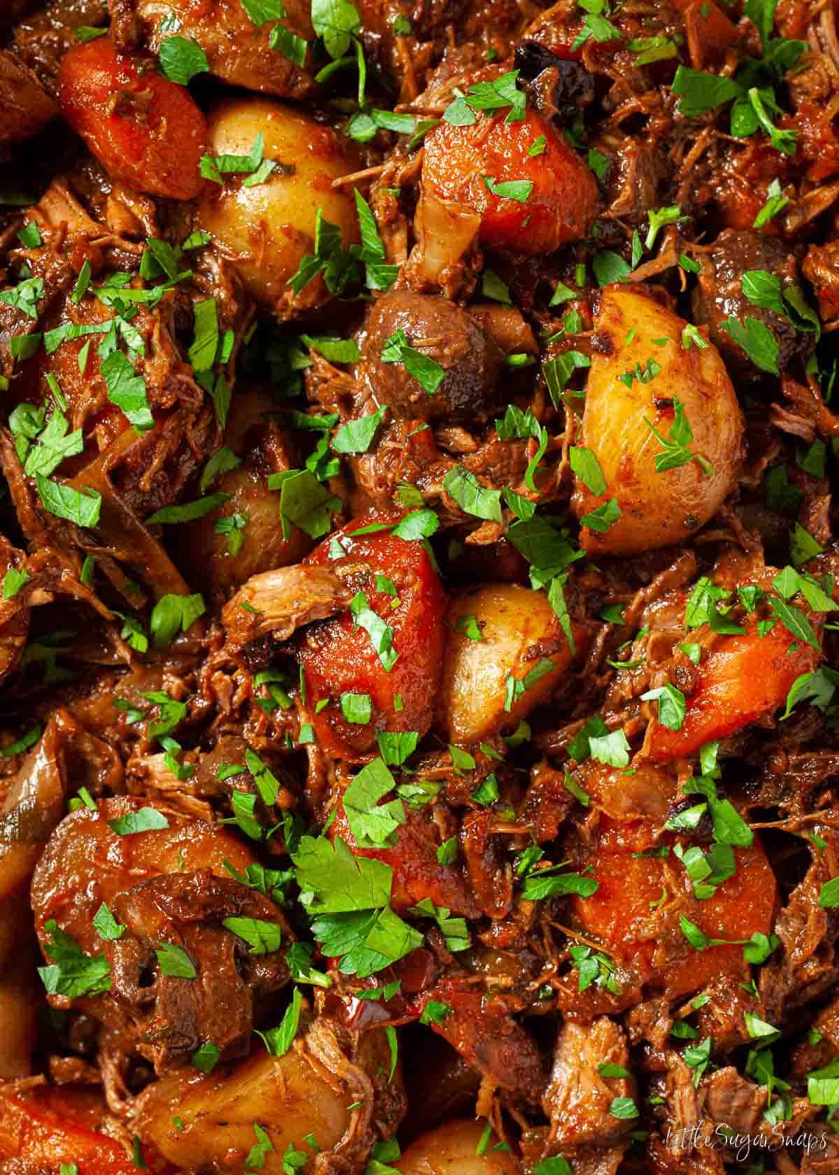 Close up of beef and mushroom stew sprinkled with fresh parsley.