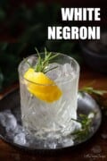 A labelled image of a Negroni Bianco garnished with lemon zest and rosemary.